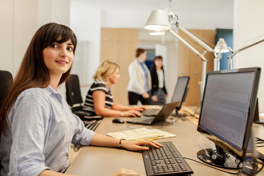 Mitarbeiterin im Medizincontrolling an einem modernen Arbeitsplatz.