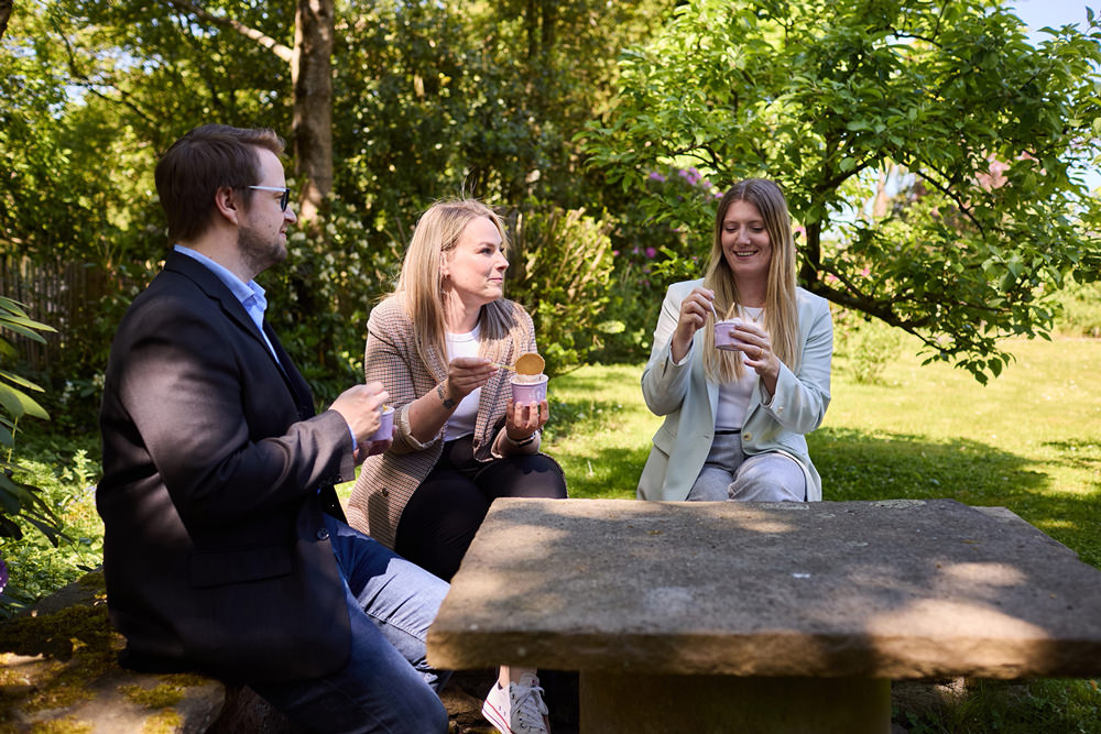Austausch im Team Mitarbeitende der DLMC tauschen sich während einer gemeinsamen Pause im Garten aus.