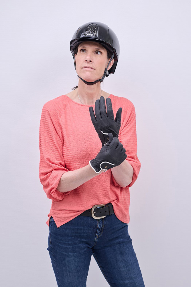 Dr. med. Nicola Breithaupt Dr. med. Nicola Breithaupt mit Reithelm und Reithandschuhen.
