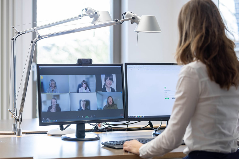 Digitale Zusammenarbeit bei DLMC Mitarbeiterin der DLMC nimmt an einer digitalen Besprechung mit Kundinnen und Kunden per Videokonferenz teil.